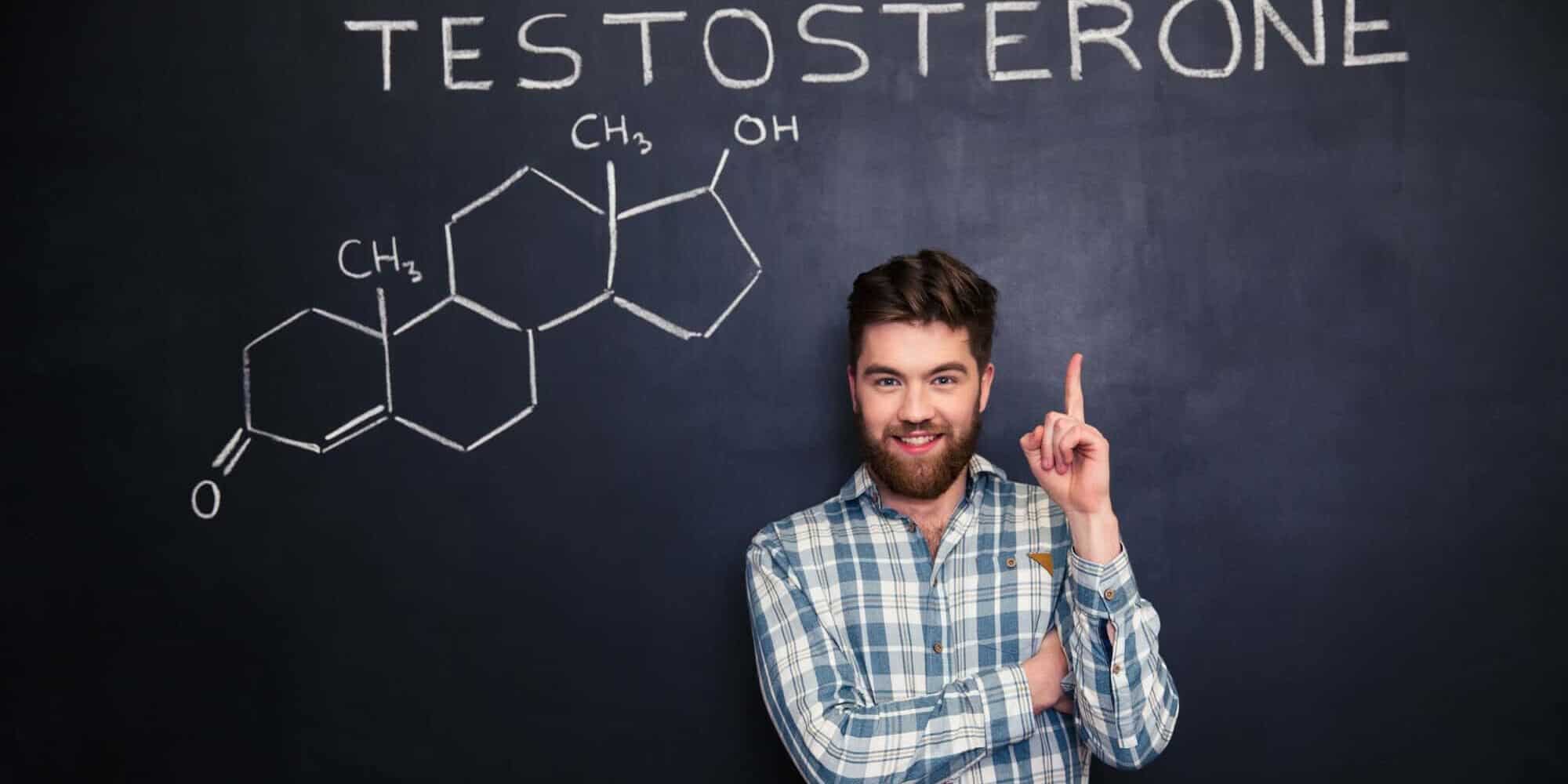 Confident man pointing on chemical structure of testosterone at chalkboard signs of low testosterone